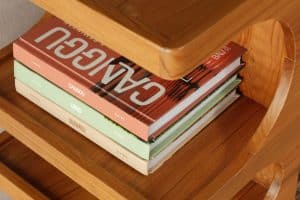 Stay In guides displayed on a wooden shelf in a modern bookshelf