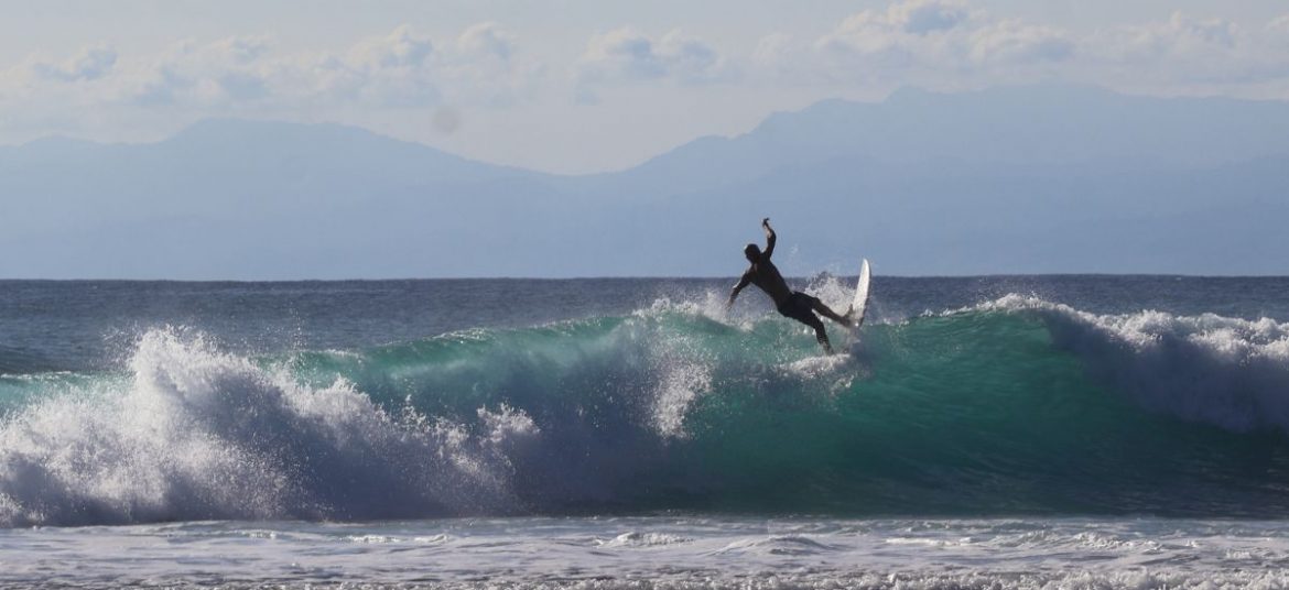 Surfing Waves at Canggu Beach, Bali Surfer riding a wave at Canggu beach, Bali