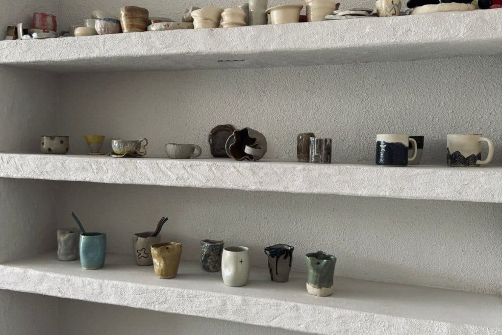 handmade ceramic mugs displayed on a wall shelf