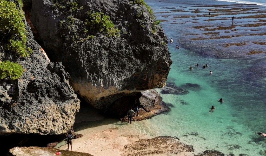 Suluban Beach – Cliffside View in Uluwatu, Bali Cliffside view of Suluban Beach in Uluwatu, Bali, with turquoise waves and rugged limestone formations.